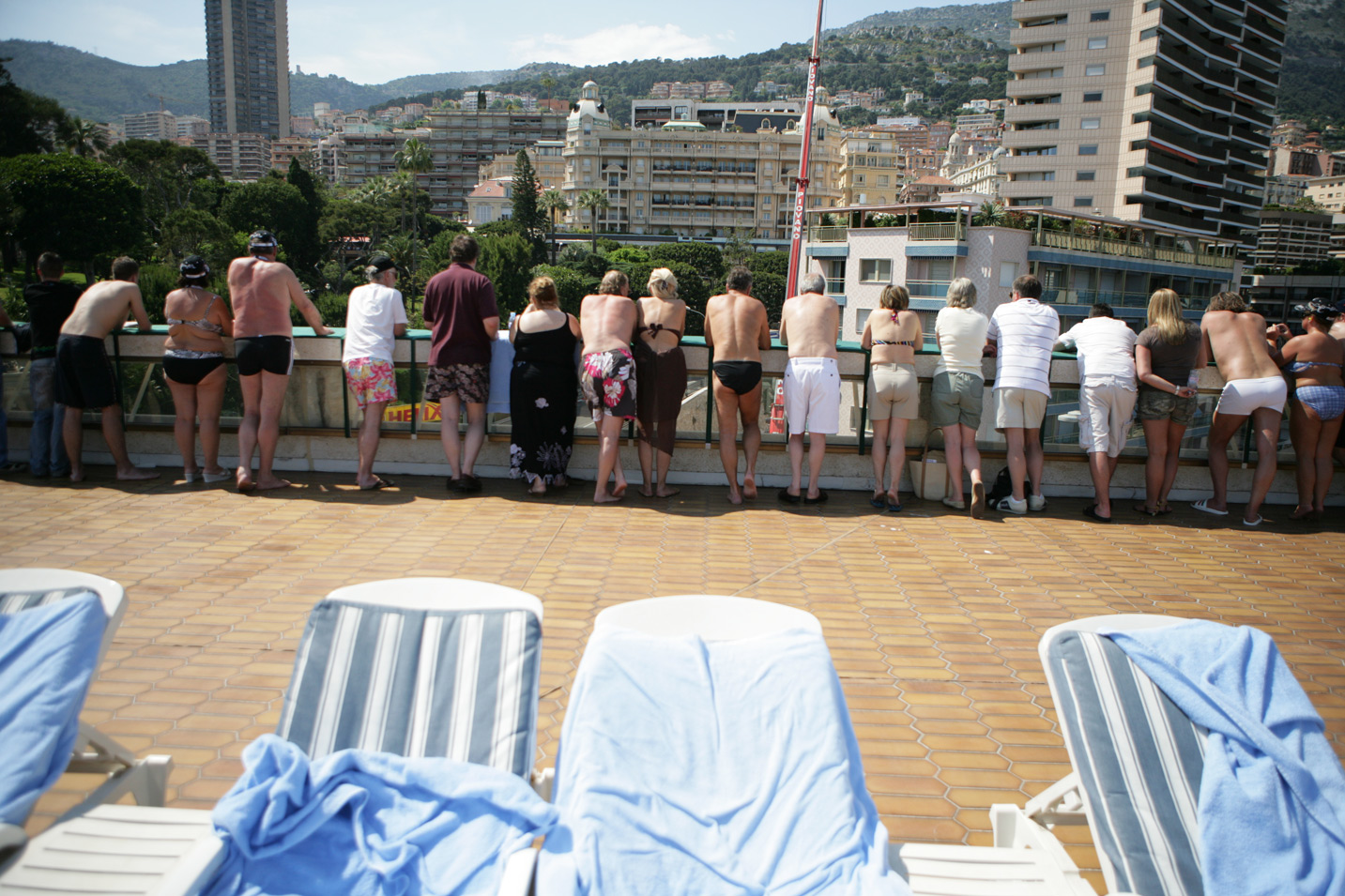 Sun worshipers take a break from tanning to watch the race, at the Monaco Grand Prix