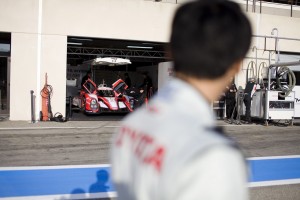 Driver Kazuki Nakajima looks over at his Toyota Hybrid car